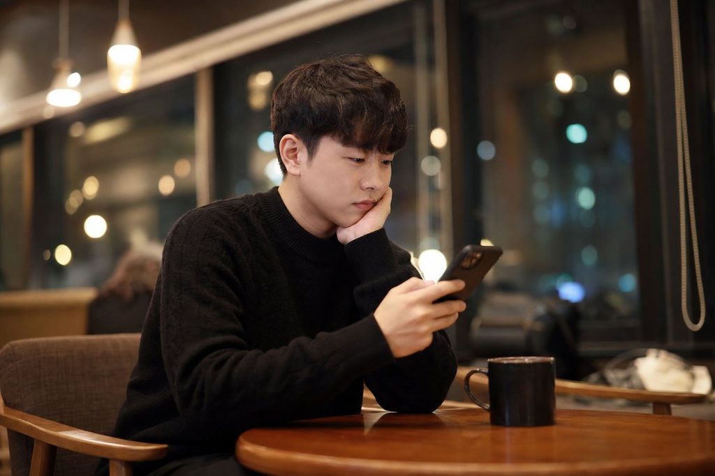 AI 재물운 예측 – 늦은 밤 카페에서 스마트폰 앱 결과를 확인하는 모습