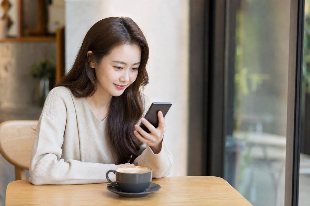 로또 번호 조합 패턴 – 카페에서 스마트폰으로 추첨 결과를 확인하는 모습