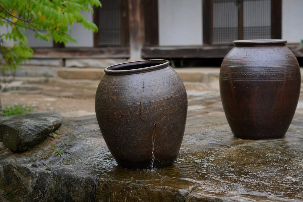 사주 재물 창고 – 금이 간 독과 온전한 독이 나란히 놓인 모습